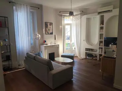 a kitchen with white cabinets and a green wall at Cannes centre superbe 3 pièces moderne 10 min à pied du Palais des festivals et croisette in Cannes