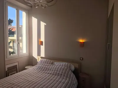 a bedroom with a bed and a window at Cannes centre superbe 3 pièces moderne 10 min à pied du Palais des festivals et croisette in Cannes
