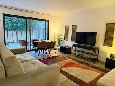 a living room with a couch and a flat screen tv at Beautiful 36m2 studio apartment & 50m2 terrace in Cannes