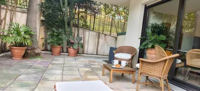 a patio with chairs and a table and plants at Beautiful 36m2 studio apartment & 50m2 terrace in Cannes