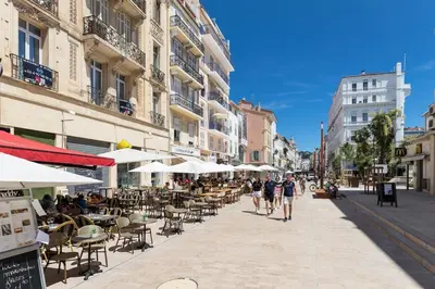 people walking down a street with tables and chairs at King size studio Rue Félix Faure 100 m Palais et plage in Cannes