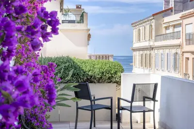 two chairs on a balcony with purple flowers at -CLR- Stunning suite with terrace in Cannes