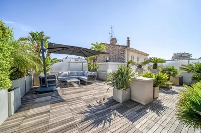 a rooftop patio with furniture and plants on a roof at -CLR- Stunning suite with terrace in Cannes