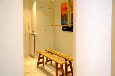 a wooden bench in a room with a painting at Appartement de standing - quartier Martinez - 70m2 in Cannes