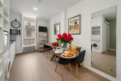 a kitchen and dining room with a table with a vase of roses at FRGK 
