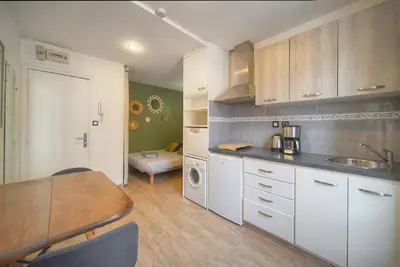 a kitchen with white cabinets and a table and a room at FRGK 