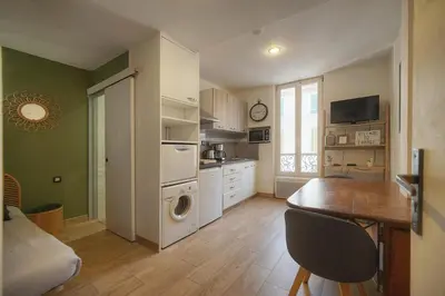 a kitchen with white cabinets and a table and a window at FRGK 