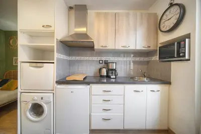 a kitchen with white cabinets and a clock on the wall at FRGK 