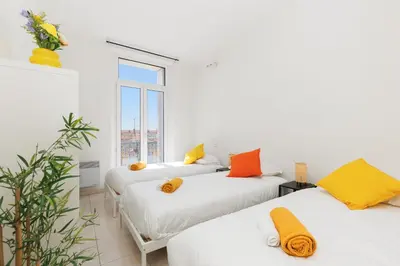 two beds in a room with white walls and a window at BnGo l Ruby Suite l 2ch, 7p, vue mer, centre in Cannes
