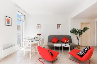 a living room with a couch and a table and chairs at BnGo l Ruby Suite l 2ch, 7p, vue mer, centre in Cannes