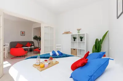 a room with a bed with blue and red pillows at BnGo l Ruby Suite l 2ch, 7p, vue mer, centre in Cannes