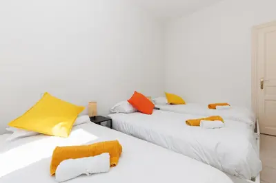two white beds with colorful pillows on them at BnGo l Ruby Suite l 2ch, 7p, vue mer, centre in Cannes