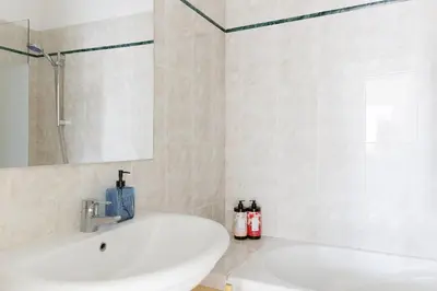 a white bathroom with a sink and a shower at BnGo l Ruby Suite l 2ch, 7p, vue mer, centre in Cannes