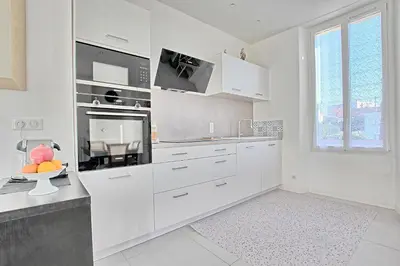 a white kitchen with white cabinets and a window at Villa Grand Jas in Cannes