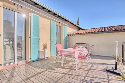 a patio with a table and chairs on a deck at Villa Grand Jas in Cannes