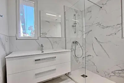 a white bathroom with a sink and a shower at Villa Grand Jas in Cannes