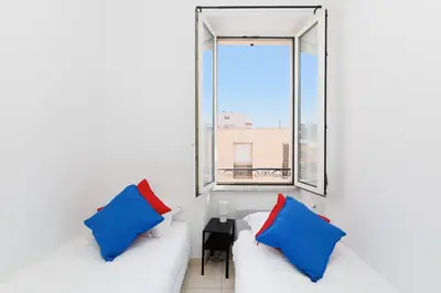 a living room with a white couch and a window at BnGo l Amber Suite l 2ch, 6 personnes, centre in Cannes