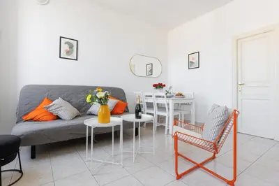 a living room with a couch and a table and chairs at BnGo l Amber Suite l 2ch, 6 personnes, centre in Cannes