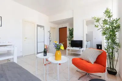 a living room with a orange chair and a table at BnGo l Amber Suite l 2ch, 6 personnes, centre in Cannes
