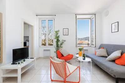 a living room with a couch and a tv at BnGo l Amber Suite l 2ch, 6 personnes, centre in Cannes