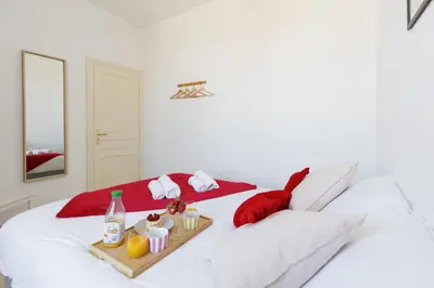 a white bed with a tray of food on it at BnGo l Amber Suite l 2ch, 6 personnes, centre in Cannes