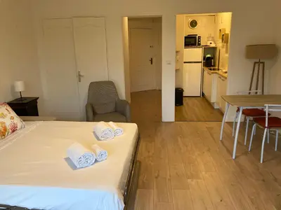 a room with a bed and a table and a kitchen at Grand studio pointe croisette in Cannes
