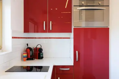 a kitchen with red cabinets and a sink at Santa Cruz YourHostHelper in Cannes