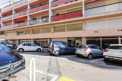a parking lot with cars parked in front of a building at Santa Cruz YourHostHelper in Cannes