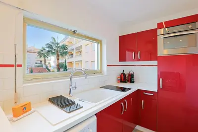a red kitchen with a sink and a window at Santa Cruz YourHostHelper in Cannes