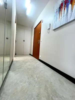 a hallway with white walls and a door and a mirror at Appartement cosy proche de la Croisette in Cannes