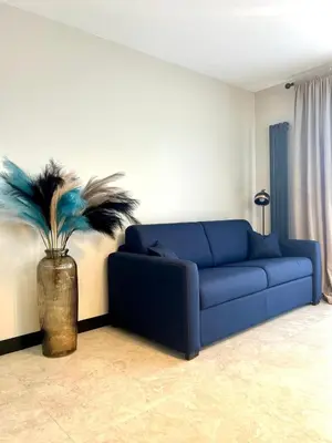 a blue couch in a living room with a plant at Appartement cosy proche de la Croisette in Cannes