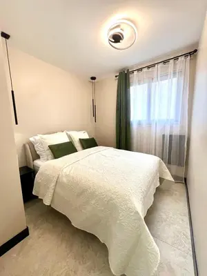 a bedroom with a white bed and a window at Appartement cosy proche de la Croisette in Cannes
