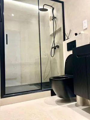 a bathroom with a shower and a black toilet at Appartement cosy proche de la Croisette in Cannes