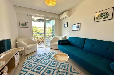 a living room with a blue couch and a tv at Cozy apartment with terrace in Cannes in Cannes