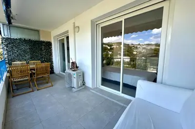 a room with a balcony with a bed and a window at Cozy apartment with terrace in Cannes in Cannes