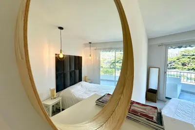 a mirror in a bedroom with a bed and a bed sqor at Cozy apartment with terrace in Cannes in Cannes