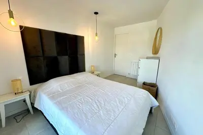 a bedroom with a large white bed and a table at Cozy apartment with terrace in Cannes in Cannes