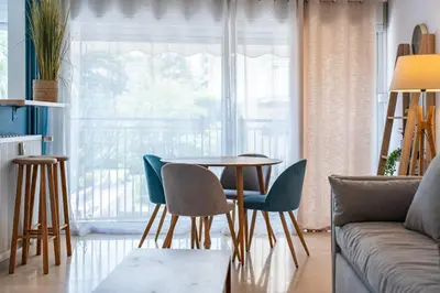 a living room with a table and chairs and a couch at 2 pièces - Centre-ville Cannes - Grand lit double in Cannes