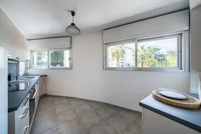 a kitchen with white walls and two windows at 2 pièces - Centre-ville Cannes - Grand lit double in Cannes