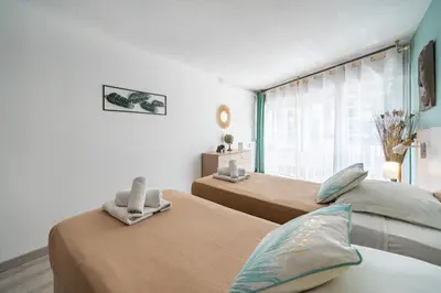 a bedroom with two beds and a window at 2 pièces - Centre-ville Cannes - Grand lit double in Cannes
