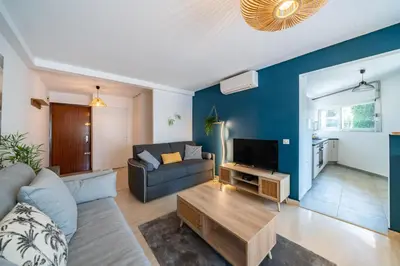 a living room with a couch and a tv at 2 pièces - Centre-ville Cannes - Grand lit double in Cannes
