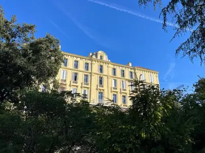 a group of chairs in a park with trees at Hôtel-résidence-Windsor in Cannes