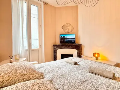 a bedroom with a bed with a fireplace and a television at Le Palme d'Or, 3 pièces - impasse privée - 7 pers in Cannes