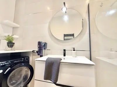 a bathroom with a sink and a washing machine at Le Palme d'Or, 3 pièces - impasse privée - 7 pers in Cannes