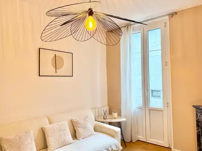 a living room with a couch and a chandelier at Le Palme d'Or, 3 pièces - impasse privée - 7 pers in Cannes