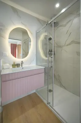 a bathroom with a shower and a sink and a mirror at Mimosa 2BR with Balcony - Walk to Palais and Beach in Cannes