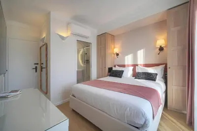 a bedroom with a large bed and a bathroom at Mimosa 2BR with Balcony - Walk to Palais and Beach in Cannes