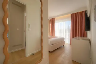 a room with a bedroom with a bed and a mirror at Mimosa 2BR with Balcony - Walk to Palais and Beach in Cannes
