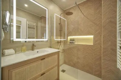 a bathroom with a sink and a mirror at Mimosa 2BR with Balcony - Walk to Palais and Beach in Cannes
