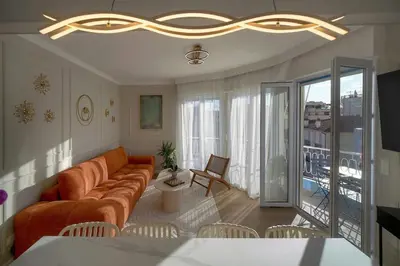 a living room with a couch and a balcony at Mimosa 2BR with Balcony - Walk to Palais and Beach in Cannes